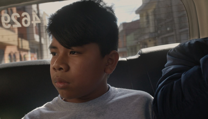 A young boy in the back of a car shown in a still from Jeremy Levine's most recent film